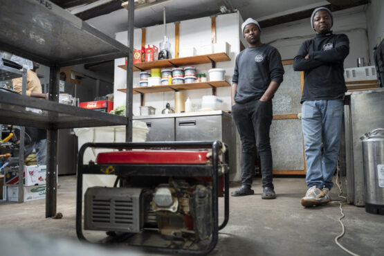 Workers Munashe Mudadi (left) and Arthur Mazivanhanga (right) with a generator that is used temporarily when there are electricity outages at the Cape Farmhouse Beer Garden in the Cape Peninsula. Image: Ihsaan Haffejee